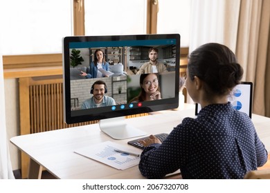 Rear back view focused serious millennial Indian businesswoman looking at computer monitor, discussing marketing research results report with colleagues by web camera video call conversation. - Shutterstock ID 2067320708