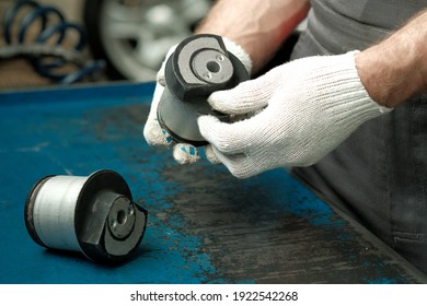 The Rear Beam Silent Block Is In The Hands Of An Auto Mechanic.A Structural Element Of The Car's Rear Suspension. Close-up. Car Spare Parts.