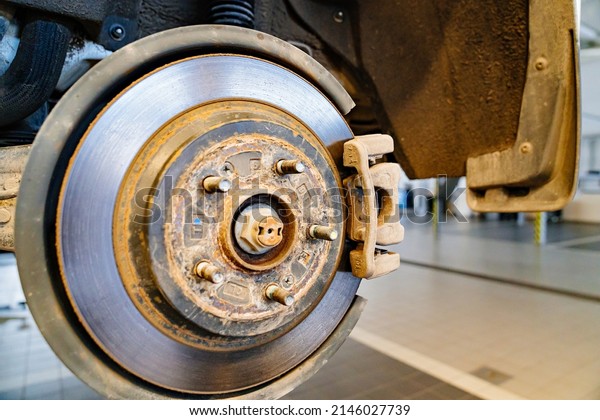 the rear brake disc\
of the car. the rotating part of the disc system, to which fixed\
brake pads are pressed with the help of a drive. maintenance in the\
car repair shop.