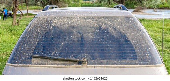 Rear Car Glass Covered In Dust After Driving On A Dirt Road