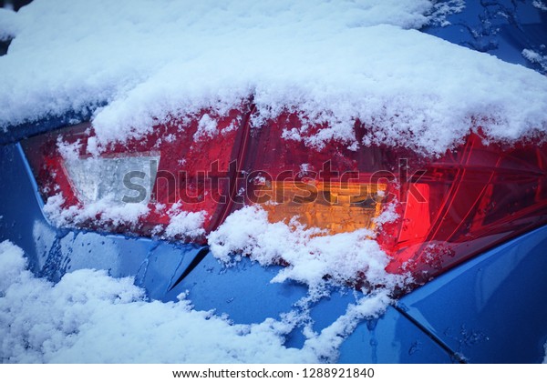 Rear car\
lamp covered with snow, closeup. Winter\
car.