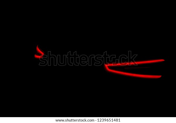 Rear car lights on a black background. Cars\
light trails. Night city road with traffic headlight. Light up road\
by vehicle. Car lights at\
night