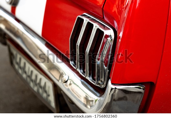 Rear chrome headlight of a red retro car. Vintage
vehicle with white lines and a metal bumper. Modern tuning. High
quality photo