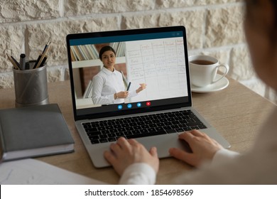 Rear Close Up View Young Woman Attending Online Educational Class, Practicing Foreign Language With Female Indian Ethnicity Teacher, Using Video Call Laptop App, E-learning Distant Study Concept.