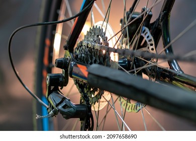 The Rear Derailleur Of A Mountain Bike Is A Close-up On A Black Background. Mountain Bike Repair In The Workshop. Dirty Mountain Bike After The Competition.