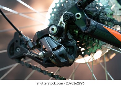 The Rear Derailleur Of A Mountain Bike Is A Close-up On A Black Background. Mountain Bike Repair In The Workshop. Dirty Mountain Bike After The Competition.