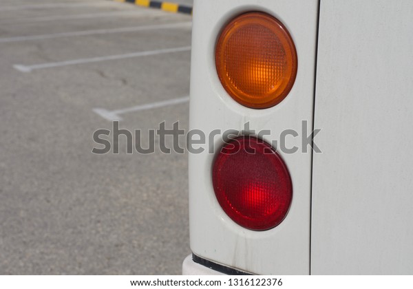 Rear drivers side Van lights\
red and orange. Middle East. Concrete to left of image. copy space.\
