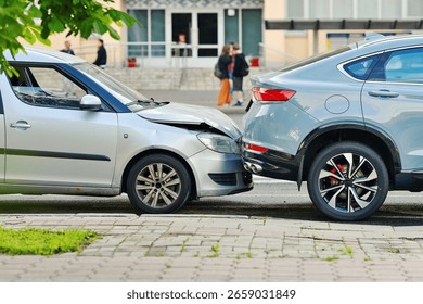Rear end collision between two cars on urban street with visible damage to bumper and hood, traffic accident. Damaged vehicles after rear end crash on city road, clear impact and crumpled front bumper