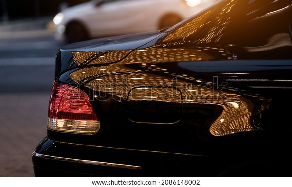 the rear headlight of the car. side view of the car\
with glare