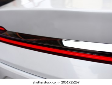 Rear LED headlamp of a modern car. Brake taillight. Red stop lighting of highway vehicles. Cars ambient lighting. Cars taillight decorative frame ABS plastic