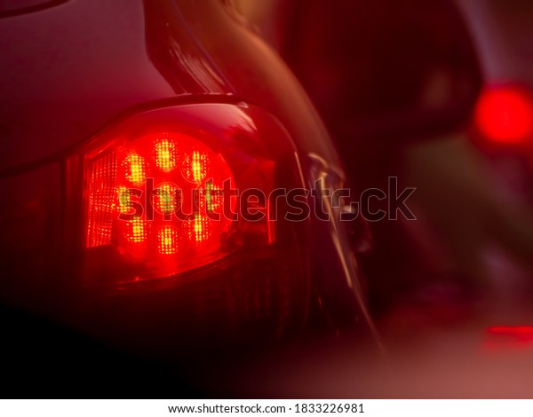 Rear lights of the\
car. Red brake lights. Colorful background or texture. Copy space.\
Selected focus