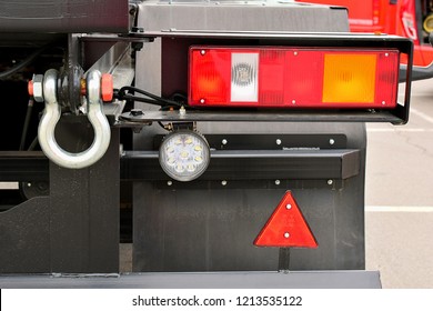 The Rear Lights Of The Truck. The Back Of The Truck Close-up. Rectangular Lights, Fog Light, Tow Hook. There's A Red Retroreflector On The Rear Mudguard.