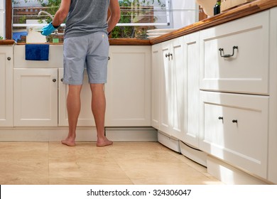 Rear Low Angle View Of Male In The Kitchen Doing Household Chores