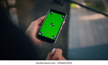 Rear over shoulder view businesswoman using smartphone green screen chroma key mobile mockup unknown girl woman hold phone with copy space cellphone device business app online order in city outdoors - Powered by Shutterstock