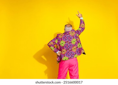 Rear photo of nice elegant man raise hand point finger empty space ad isolated on yellow color background - Powered by Shutterstock