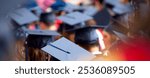 Rear photo of people graduation. Graduands close up photo with their graduation cap on top of their head and graduation gown. 