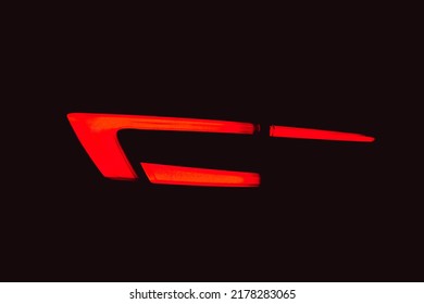 Rear red car LED lights in the dark. Bright modern car headlights on a black background. Background bright red LED car taillights in the dark. Diode stop light. 
