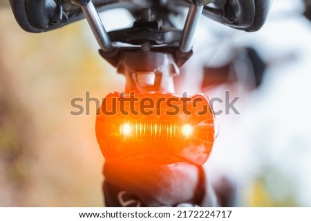 The rear red light on the bike glows brightly