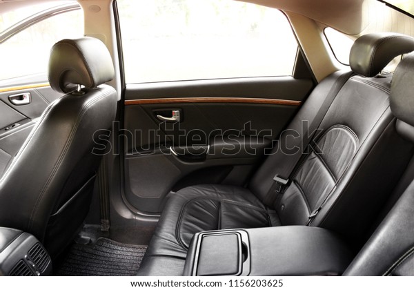 The rear\
seats of the car. Black leather\
interior