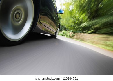 Rear Side View Of Black Family Car Driving Fast On Forest Road