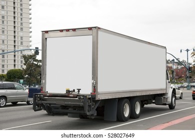 Rear And Side View Of White Delivery Truck In City Traffic. Horizontal.