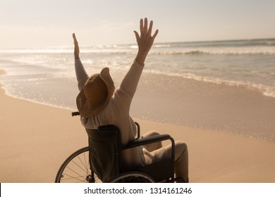 Rear view of active disabled senior woman with arms up on the beach - Shutterstock ID 1314161246