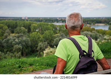 Rear View Of Active Senior Man Sitting On A Bench