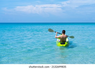 Rear View of Adult Man Kayaking in Blue Sea in Summer
