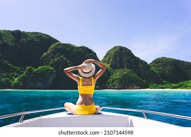 Rear view of adult traveling woman sit and relax on the sailing boat wear yellow bikini blue sky and sea. Summer vacation island domestic trip at Maya bay. Krabi, Thailand - Powered by Shutterstock