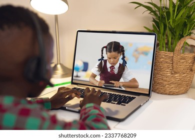 Rear view of african american boy using laptop while having a video call with biracial girl. Distant learning online education concept - Powered by Shutterstock