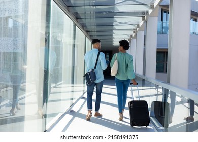 Rear View Of African American Business Colleagues Discussing While Walking With Luggage In Airport. Unaltered, Occupation, Business Travel And Transportation Concept.