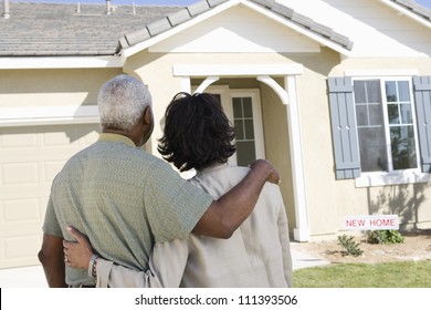 Rear View Of African American Couple Standing In Front Of New House