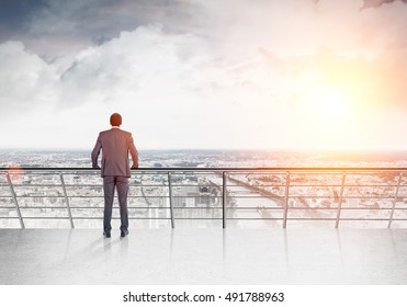 Rear View Of African American Man Looking At Large City With River And High Building And Thinking. Concept Of Business Decision Making. Toned Image