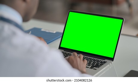 Rear View of African Doctor using Laptop with Green Chroma Screen  - Powered by Shutterstock