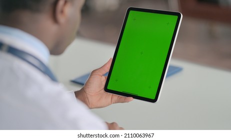 Rear View Of African Doctor Using Tablet With Green Chroma Screen 