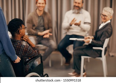 Rear View Of African Young Disabled Man Visiting Training Class And People Clapping Him