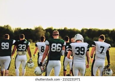 Rear view of an American football team walking on a playing field during a practice in the late afternoon - Shutterstock ID 2152231971