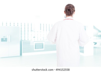 Rear View Of Anonymous Woman Medic In White Coat With Stethoscope And Advertising Area