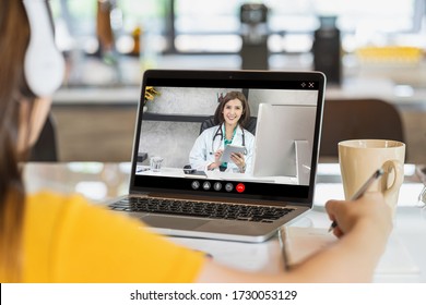 Rear View Of Asian Business Woman Discussing With Doctor To Follow Up The Sickness In Video Conference When Coronavirus Outbreak, Covid-19 Pandemic, Online Adult Counselling And New Normal Concept