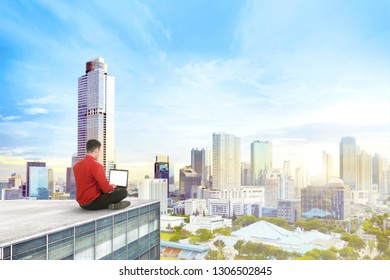 Rear View Of Asian Businessman Sitting And Working With Laptop On The Rooftop