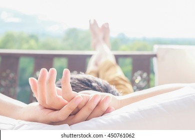 Rear View Of Asian Man Relaxing On A Sofa And Looking Outside A Green Background View At Home Terrace. Relaxing Concept.