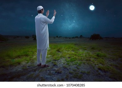 Rear View Of Asian Muslim Man Praying With Night Scene Background