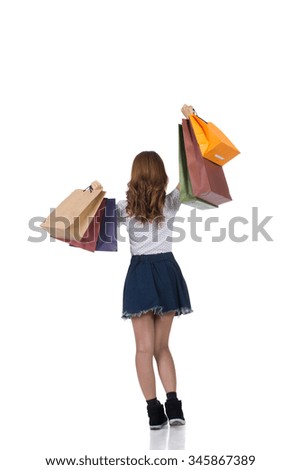 Rear view of Asian shopping woman holding bags, full length portrait isolated.