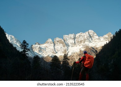 rear view of asian trekker looking at mount jiawaren-an, part of the meili snow mountains in yunnan province, china
