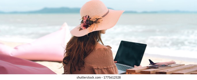 Rear View Of Asian Woman Relax At Beach Cafe On Summer Holiday. Outdoor Lifestyle With Modern Technology. Work And Travel Domestic. Sea And Sky Banner Size Background. Pattaya, Thailand