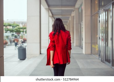 Rear View Of Asian Woman Walking Outdoors In Business Casual Red Suite Against City Mall