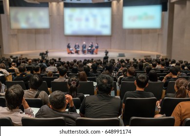 Rear View Of Audience Over The Speakers On The Stage In The Conference Hall Or Seminar Meeting, Business And Education Concept