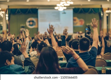 Rear view of Audience showing hand to answer the question from Speaker on the stage in the conference hall or seminar meeting, business and education concept - Shutterstock ID 1105566605