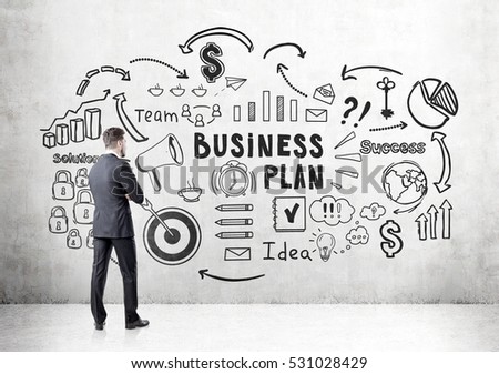Rear view of a bearded businessman looking at a business plan sketch depicted at a concrete wall. Concept of strategy development