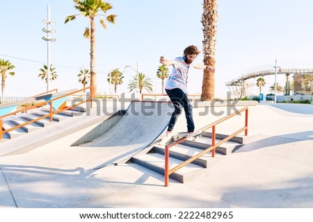 Similar – Image, Stock Photo Young bearded skater performing trick in skatepark